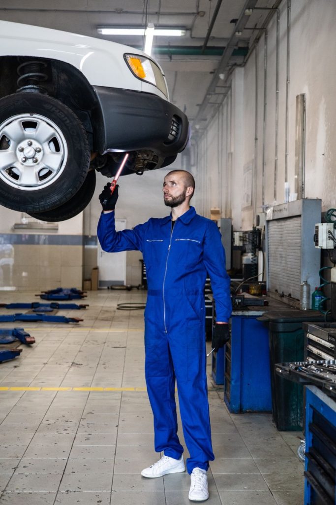 Mechanik sprawdza podwozie auta na podnosniku