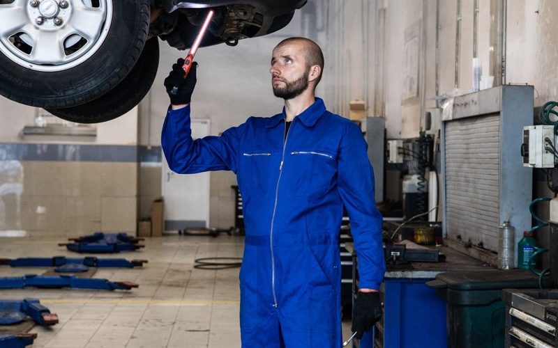 Mechanik sprawdza podwozie auta na podnosniku